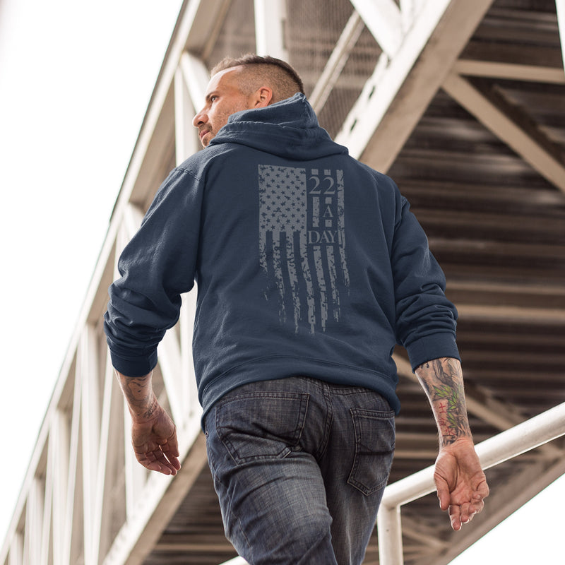Back view of men’s 22 A Day hoodie with bold distressed American flag and 22 A Day veteran suicide awareness graphic.