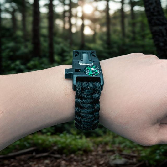 Black 550 paracord bracelet with built-in compass and survival tools worn on wrist.