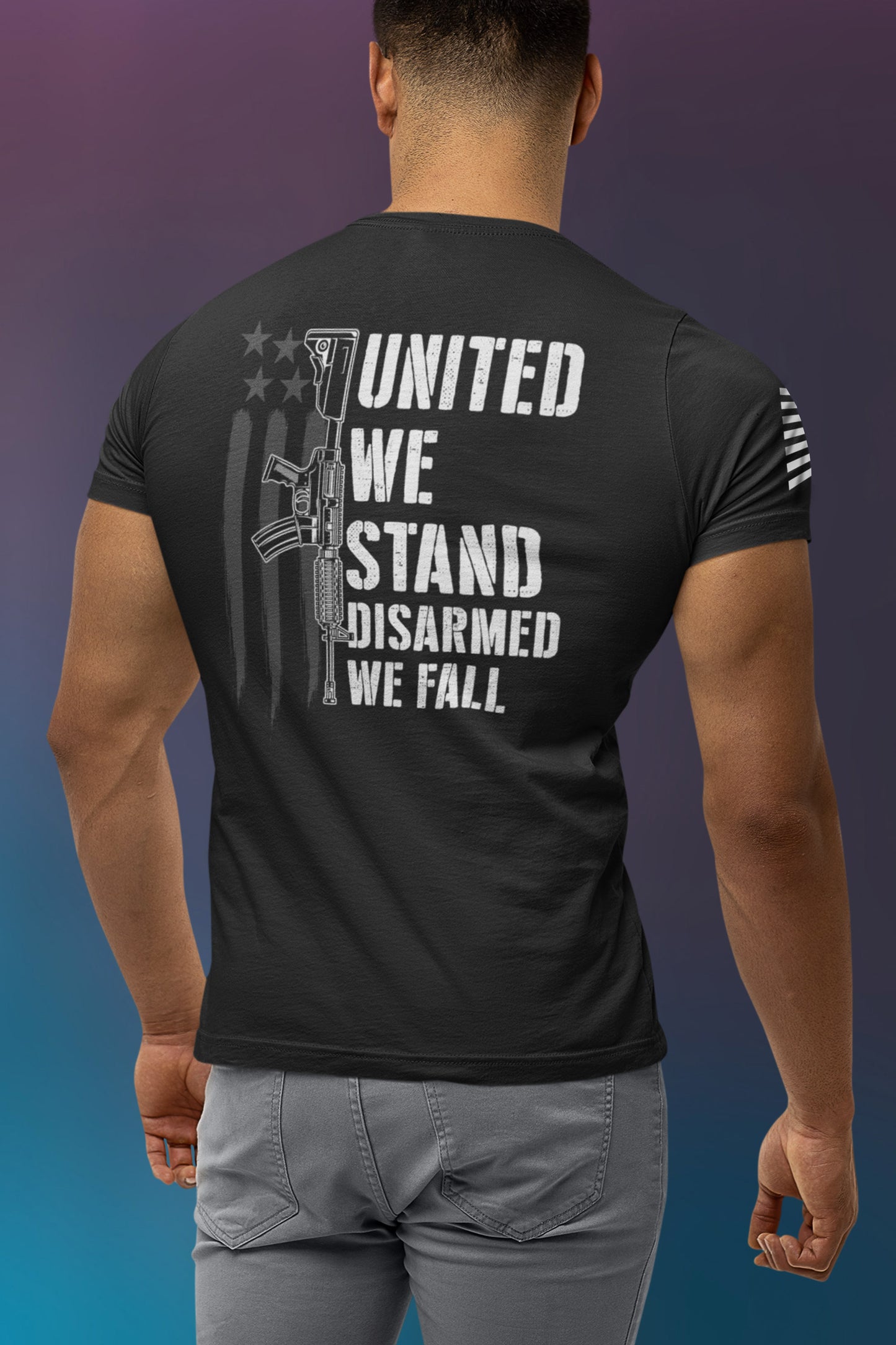 Back view of man in Disarmed We Fall 2nd amendment t-shirt showing white rifle graphic with text ‘United We Stand, Disarmed We Fall’ over distressed American flag background.