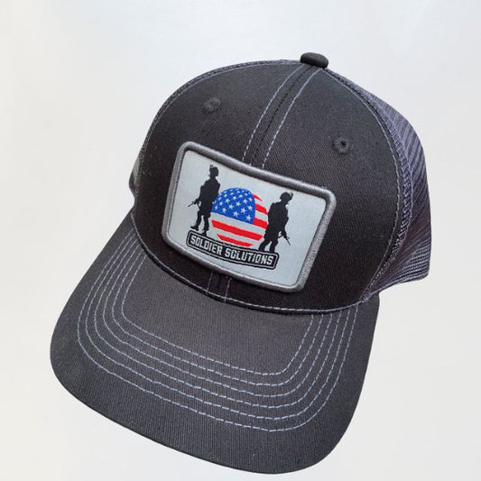 Front view of black mesh back hat featuring Soldier Solutions logo patch with American flag