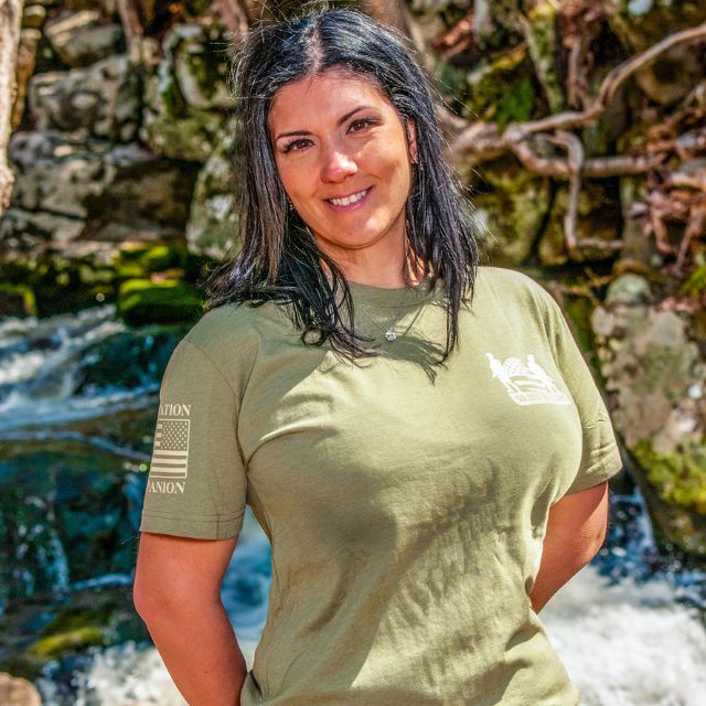 Woman wearing We Got Your Six shirt front view with Soldier Solutions logo on chest
