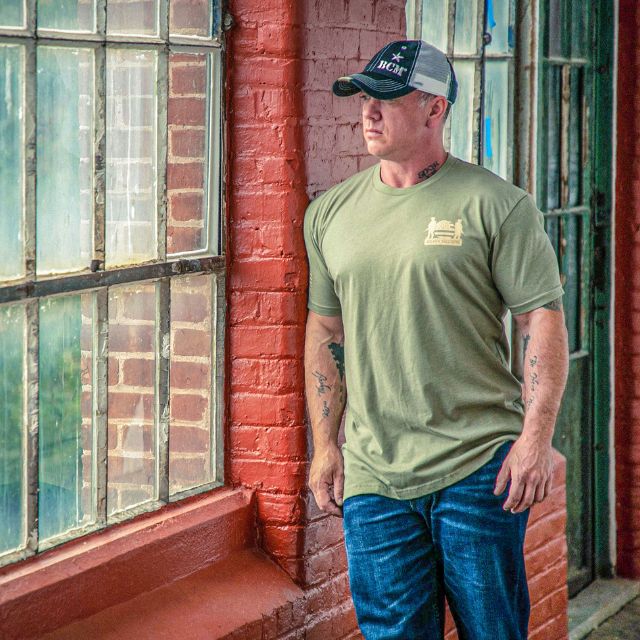 Man wearing front of Soldier Solutions We Got Your Six shirt with logo