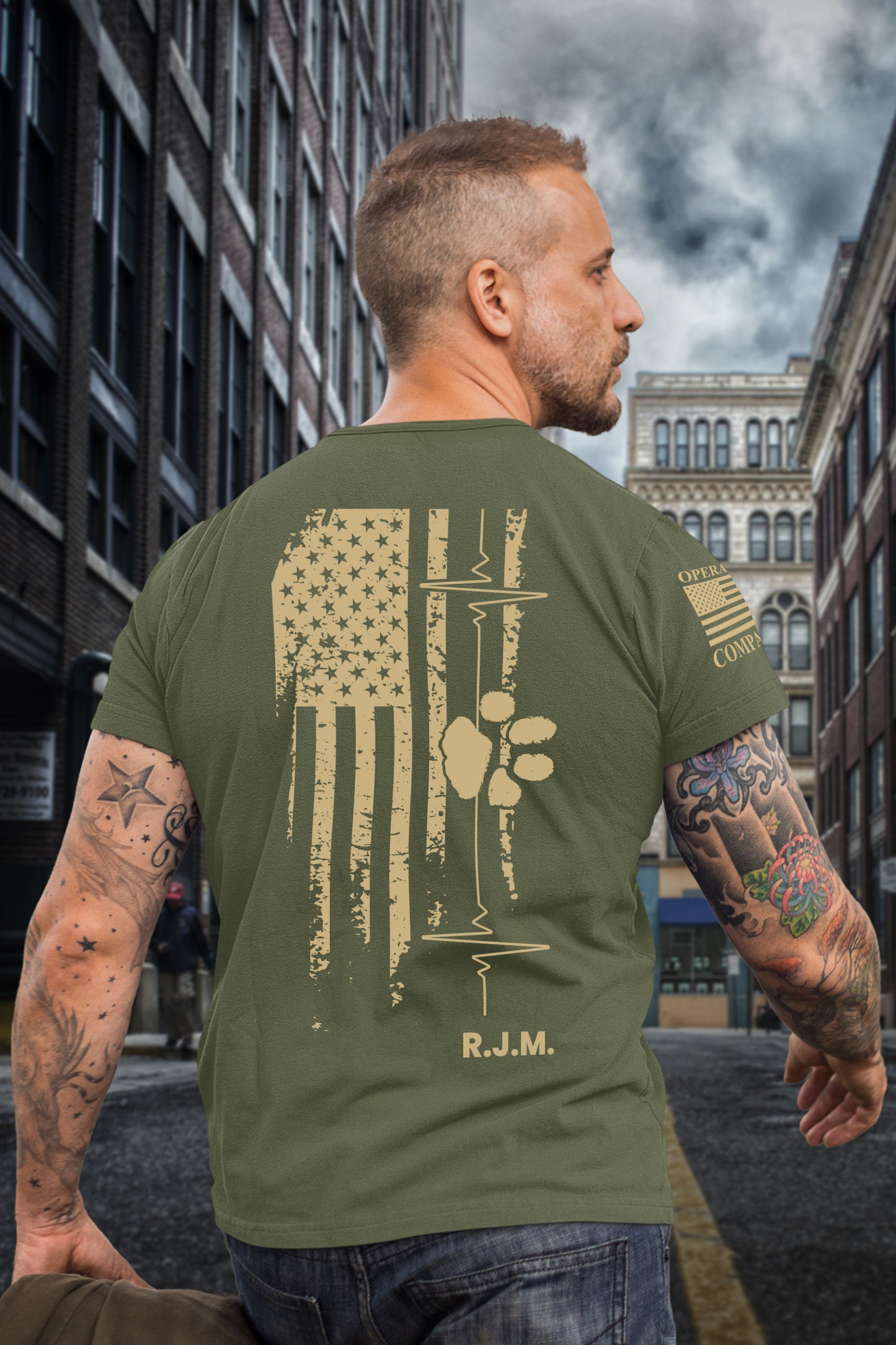 Full back view of men’s tribute t-shirt featuring American flag, heartbeat, paw print, and R.J.M. initials in honor of a fallen veteran.