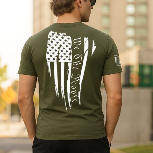 Back of men’s olive green shirt with distressed American flag and We The People graphic
