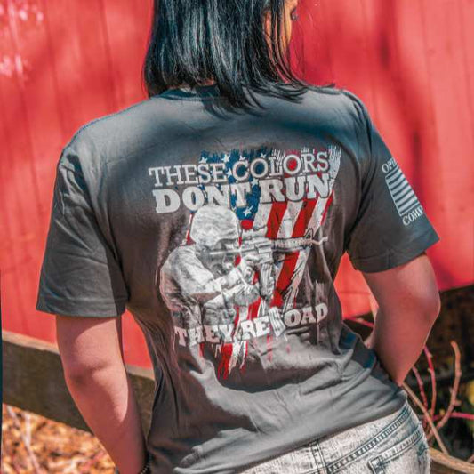 Woman wearing patriotic American flag shirt for women with rifleman graphic and These Colors Don’t Run They Reload text