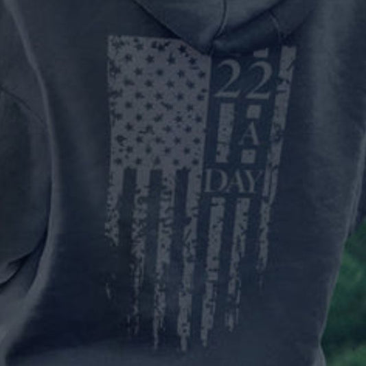 Close-up of distressed flag and 22 A Day graphic on back of women’s patriotic hoodie raising PTSD awareness.