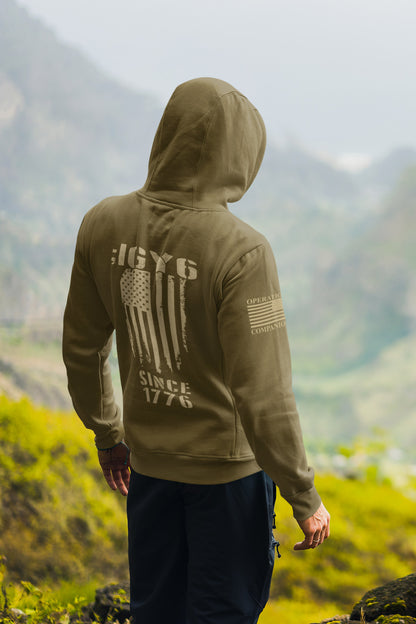 Patriotic IGY6 hoodie for men showing distressed flag and Since 1776 print with American flag patch on sleeve.