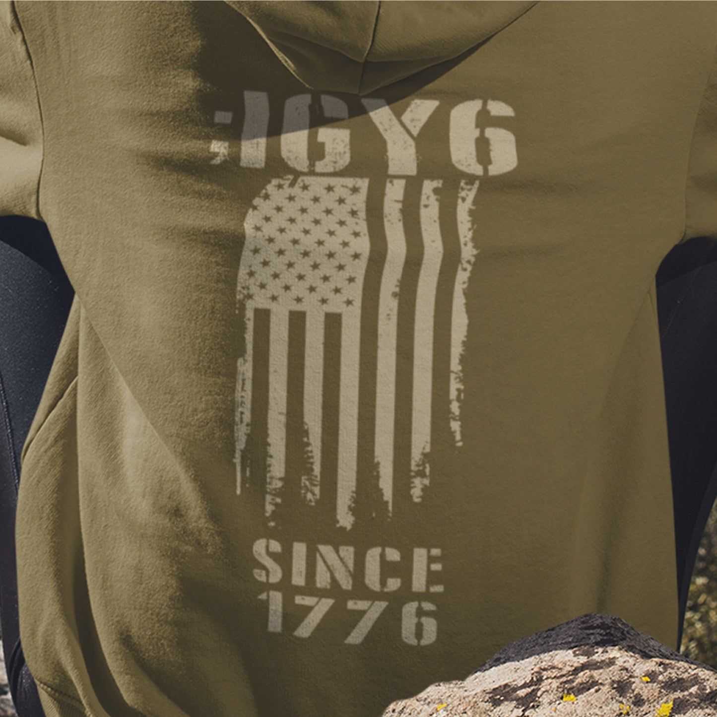 Close up of IGY6 Since 1776 women’s hoodie featuring distressed American flag and bold patriotic back print with sleeve insignia.