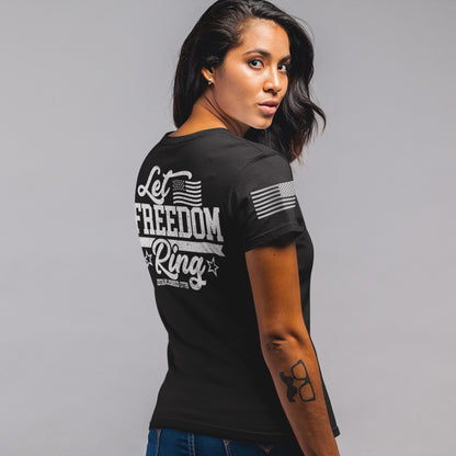 Back view of woman in Let Freedom Ring patriotic shirt showing bold ‘Let Freedom Ring – Established 1776’ text and American flag sleeve design.