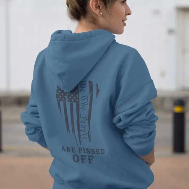 Woman wearing patriotic “We The People Are Pissed Off” American flag hoodie